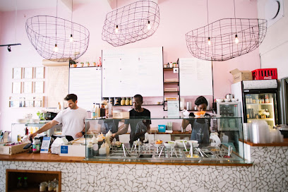The Poke Co. counter with staff preparing poke bowls in a pink café