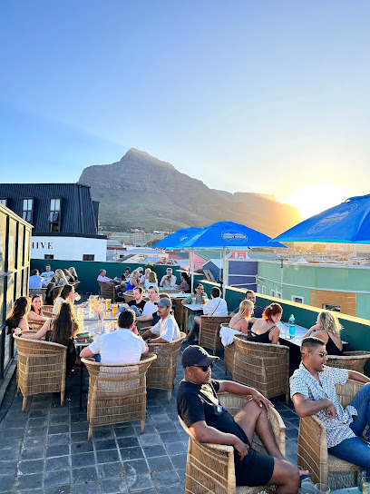 Guests dining on Pizza Shed Observatory rooftop at sunset with mountain view