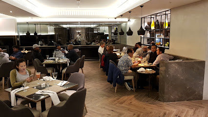 Busy modern restaurant dining room with seated guests and servers