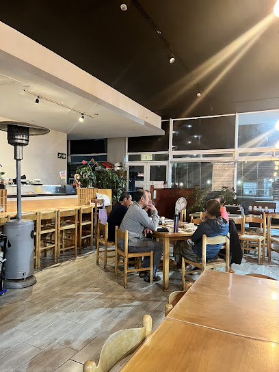 Interior of Yuz Sushi Bar with diners seated at wooden tables
