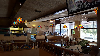 Navaho Spur dining room with booths, wooden railings, stained-glass pendant lamps and large windows