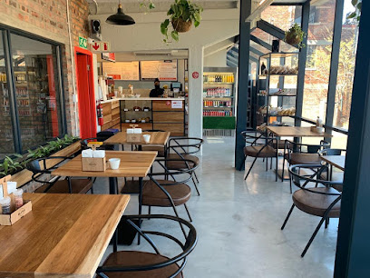 Mill & Press Café interior at Old Castle Brewery with wooden tables and metal chairs