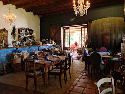 Evert Opstal Restaurant rustic dining room with wooden tables, chandeliers and large wine barrel