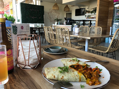 Vegetarian wrap and curry on a plate inside Prashad Café Rondebosch café
