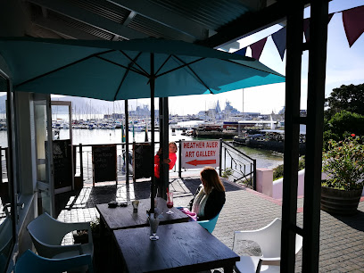 I Love Waffles Quayside outdoor seating with teal umbrella and harbor view