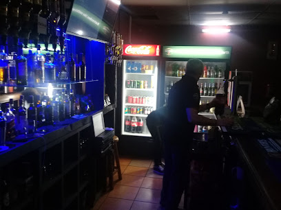 Geronimo’s Pub and Grill bar with bartender, illuminated liquor shelves and fridges