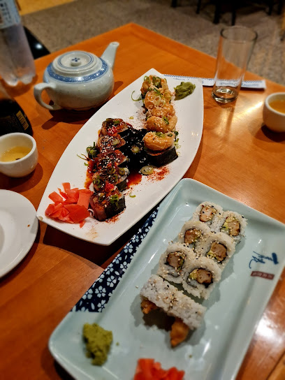Assorted sushi rolls and condiments on plates at Andy's Sushi Bar