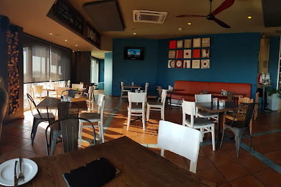 De Kelder Restaurant interior with sunlit tables and blue feature wall