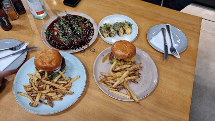 Conscious Carnivores burgers with fries, glazed meat and herb-topped shells on table