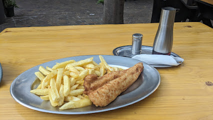 Battered fish fillet and chips on metal plate at The Fish and Chips Eatery