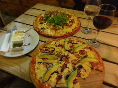 Joon pizzas topped with sliced avocado and two glasses of wine