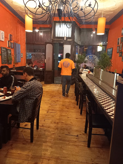 Linko Restaurant interior with orange walls, wooden floor, bar seating and diners
