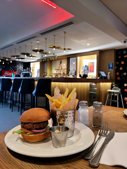 Hard Rock Cafe Cape Town burger and fries on table with bar in background
