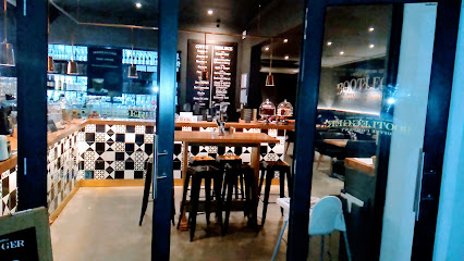 Bootlegger Tokai interior with communal wooden table, tiled counter and menu board