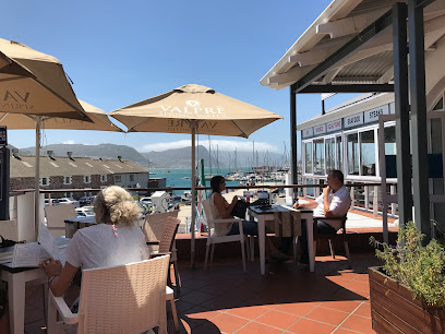 SAVEUR Restaurant terrace with diners, umbrellas and marina view
