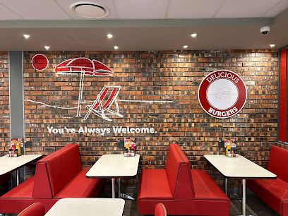 Wimpy Drive Thru interior, red booths and brick wall mural 'You're Always Welcome'