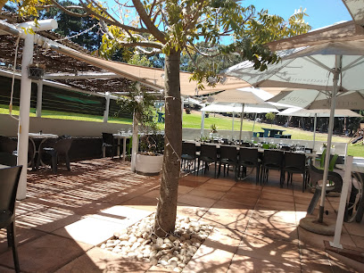 Outdoor dining terrace at Tables at Nitida with shaded tables and lawn