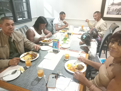Family enjoying plated meals and orange juices at On The Square Restaurant
