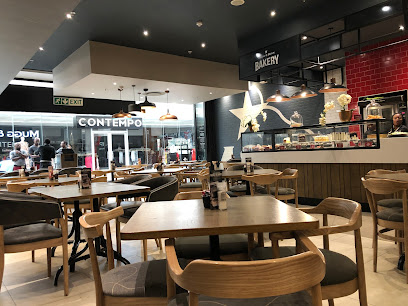 Mugg & Bean Kenilworth interior with wooden tables, chairs and bakery counter