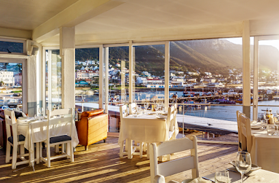 Harbour House Kalk Bay dining room with tables set and harbor views