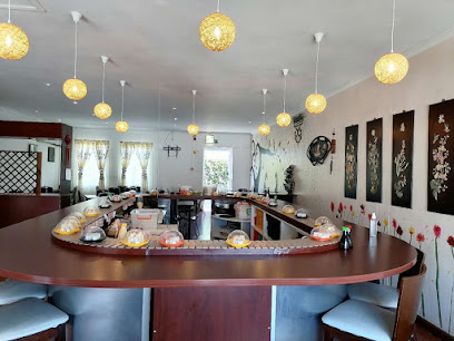 Interior of Tai Shan Restaurant with circular conveyor belt, stools, and hanging lanterns