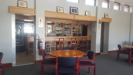 Simon's Town Country Club dining room with round wooden table and bar stools