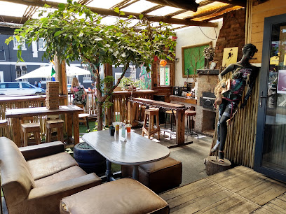 Casa Woodstock Bar covered outdoor seating with wooden tables, sofa, and bar