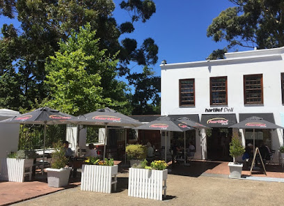 Hartlief Constantia Deli exterior with outdoor seating and umbrellas
