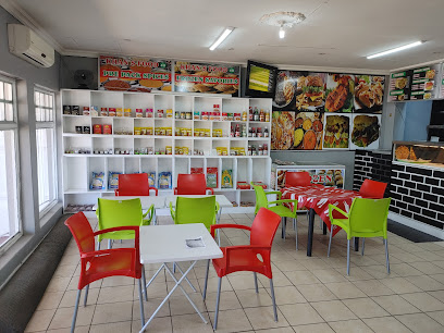 Khansfoods4u dining area with red and green chairs and menu boards