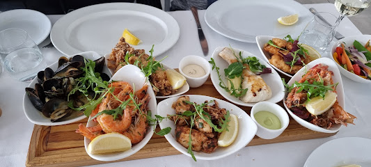 Assorted seafood tapas on a wooden board at Lucky Fish & Chips Kalk Bay
