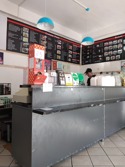 Huang Mei Sushi & Chinese Food counter with menu boards and staff member