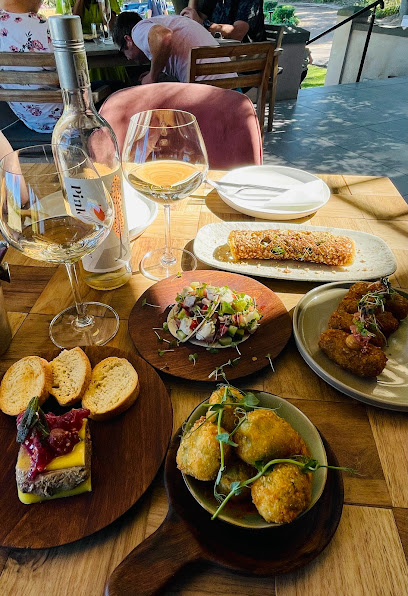 Pink Valley Wines restaurant table with wine bottle, glass and assorted small plates.