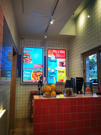 Free Bird Rondebosch counter with illuminated menu boards, bowl of oranges