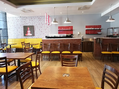 Simply Asia Woodstock dining area with wooden tables and yellow-cushioned chairs