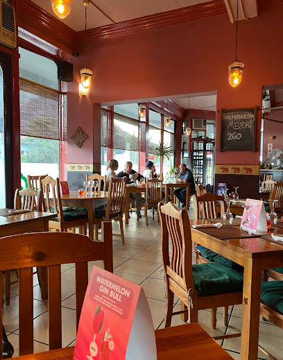 Aiyara Thai Restaurant interior with warm red decor, wooden tables and diners