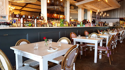 Grand Africa Café & Beach interior with white tables, wicker chairs, bar and red roses