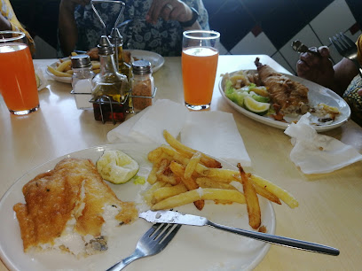 Fish 4 Africa takeaway plates with battered fish, chips, lemon wedges and orange drinks