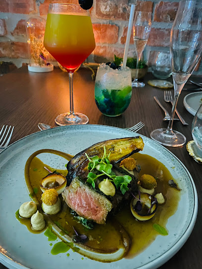 The Happy Uncles plated medium-rare steak with sauces and cocktails