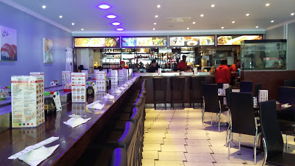 Soo She Restaurant interior with long counter, bar stools and illuminated menu boards
