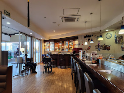 Asami’s Cape Gate interior — sushi bar counter with stools and lit drinks shelves