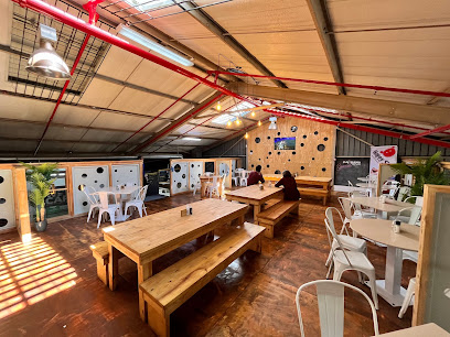 PlayStation by Rush seating area with communal wooden tables and indoor play wall