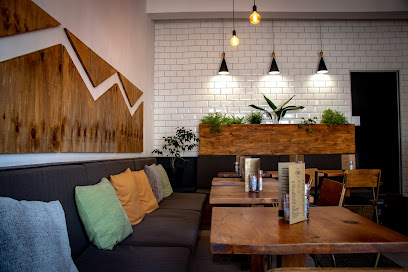 Freddie Freeloader dining area with sofa, wooden tables, pendant lights