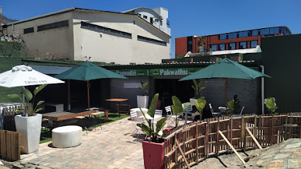 Outdoor braai seating at Pakwathu Braai Restaurant with green umbrellas
