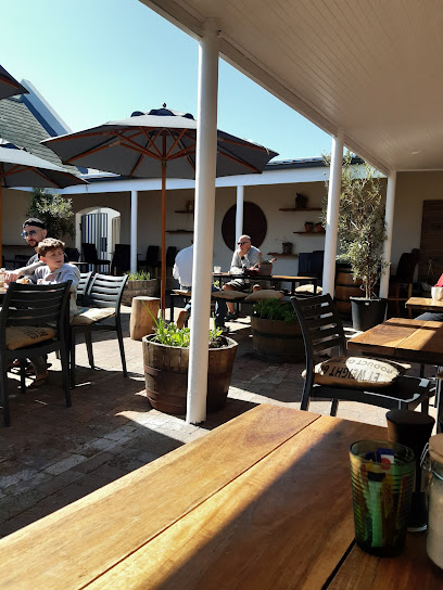 The Coffee Guy Noordhoek outdoor patio with umbrellas and diners