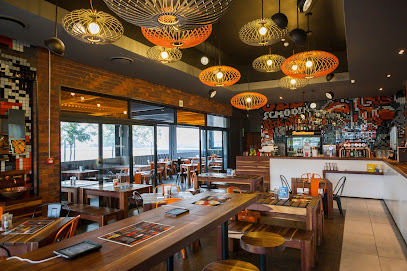 RocoMamas Okavango Crossing dining area with wooden tables and hanging lamps