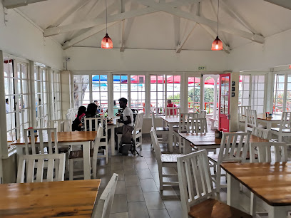 Fran’s Place dining room with wooden tables, white chairs, and seated patrons