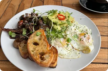 Breakfast plate with fried eggs, avocado, sautéed mushrooms and toasted sourdough