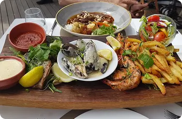 Seafood platter with mussels, grilled prawns, fries and salad
